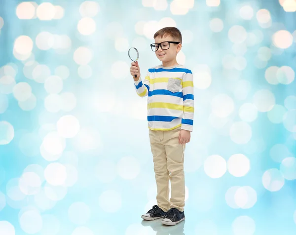 Little boy in eyeglasses with magnifying glass — Stock Photo, Image