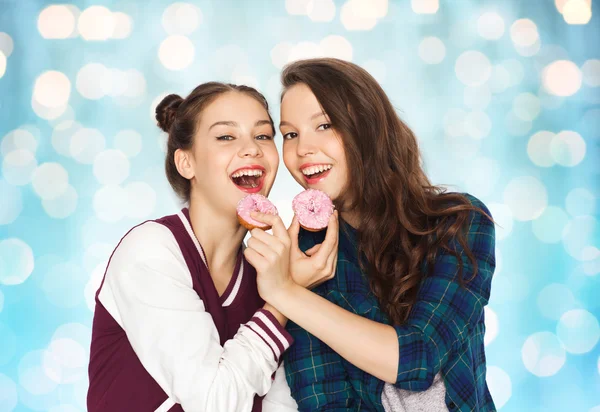 Happy pretty teenage girls eating donuts — Stock Photo, Image