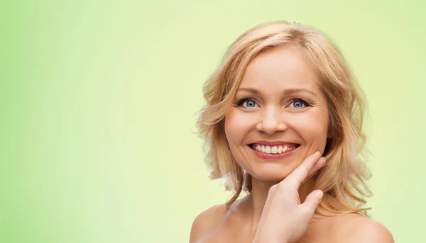 Lachende vrouw met blote schouders raken gezicht — Stockfoto