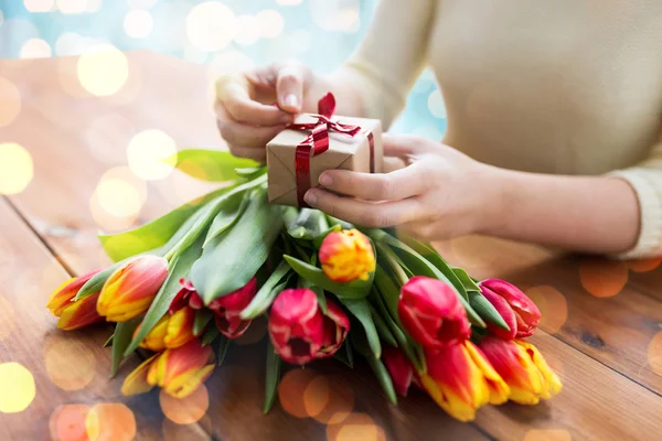 Close up of woman with gift box and tulip flowers — Stock Photo, Image