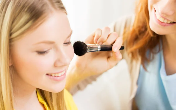 Mulheres felizes com pincel de maquiagem aplicando blush — Fotografia de Stock