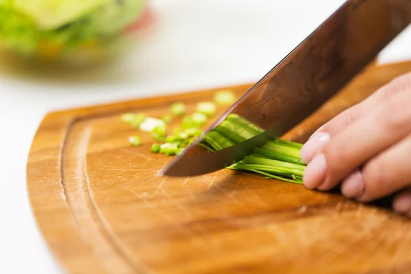 Primer plano de la mujer picando cebolla verde con cuchillo — Foto de Stock