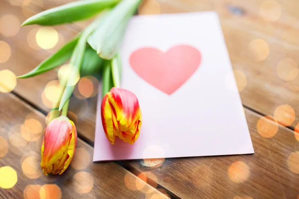Close up of flowers and greeting card with heart — Stock Photo, Image