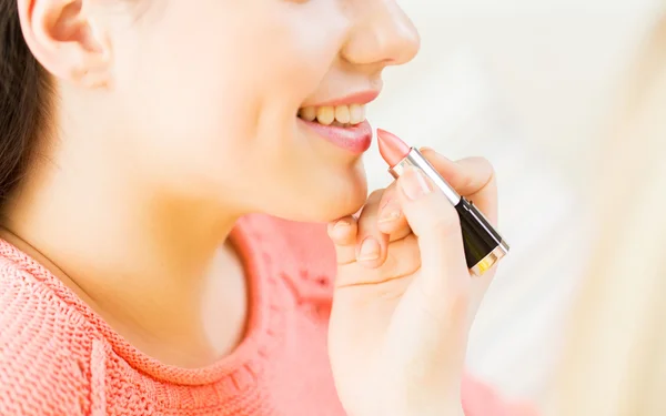 Primer plano de la mano aplicando lápiz labial a los labios de la mujer —  Fotos de Stock