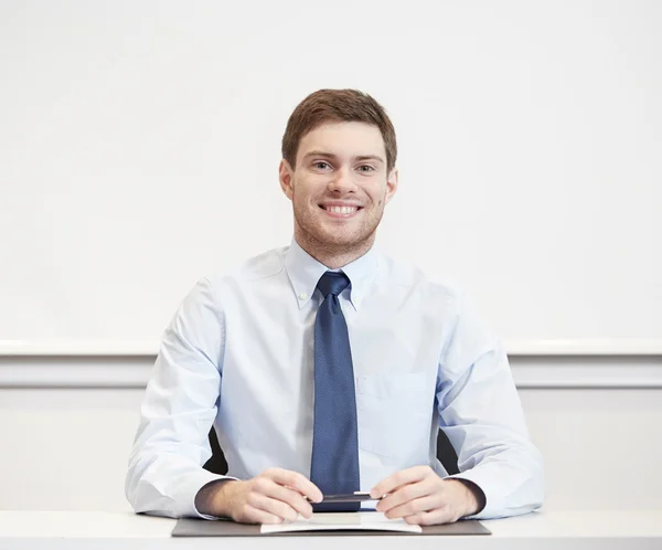 Smiling businessman sitting in office — Stock Photo, Image