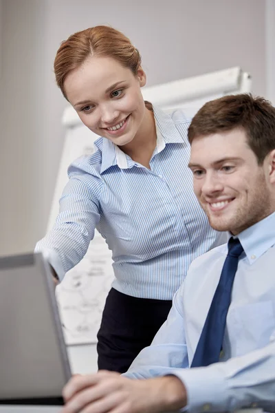 Smiling businesspeople with laptop in office — Stock Photo, Image