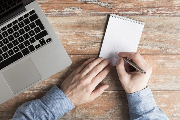 Close up of male hands with laptop and notebook — Stock Photo, Image