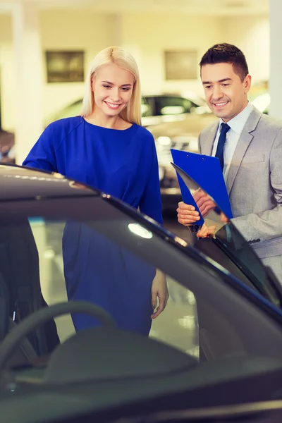 Glückliche Frau mit Autohändler in Auto-Show oder Salon — Stockfoto