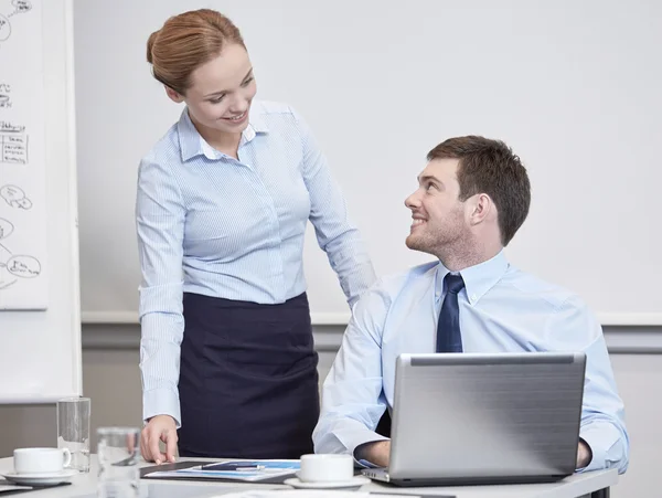 Glimlachende zakenmensen met laptop in office — Stockfoto