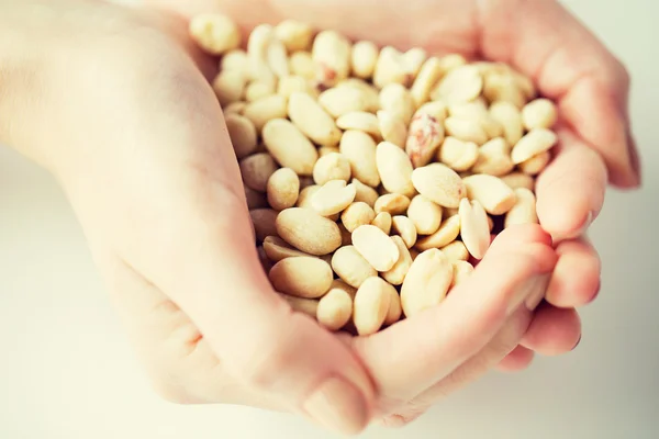 Nahaufnahme von Frauenhänden, die geschälte Erdnüsse halten — Stockfoto
