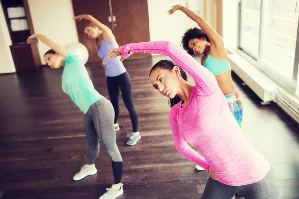 Grupo de mujeres felices haciendo ejercicio en el gimnasio — Foto de Stock