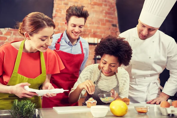 Amigos felizes e cozinheiro chef assar na cozinha — Fotografia de Stock