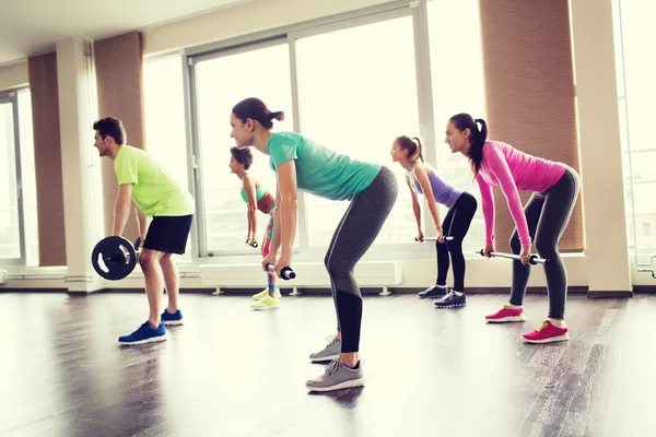 Gruppo di persone che si esercitano con il bilanciere in palestra — Foto Stock