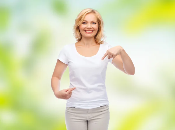 Mulher sorridente em t-shirt branca apontando para si mesma — Fotografia de Stock
