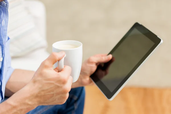 Nahaufnahme eines Mannes mit Tablet-PC und Teetasse zu Hause — Stockfoto