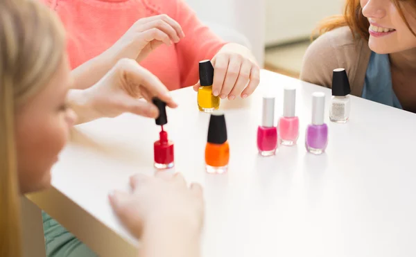 Close up of smiling young women with nail polish — Stock Photo, Image