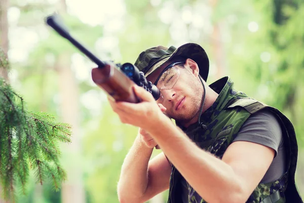 Молодой солдат или охотник с пистолетом в лесу — стоковое фото