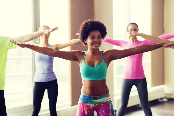 Groupe de personnes souriantes dansant en salle de gym ou studio — Photo