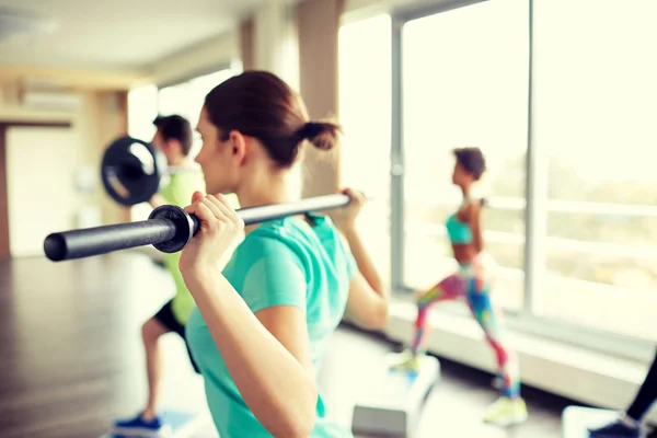 Närbild på människor tränar med barer i gym — Stockfoto