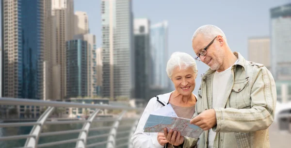 Gelukkige senior paar met kaart over dubai stad — Stockfoto