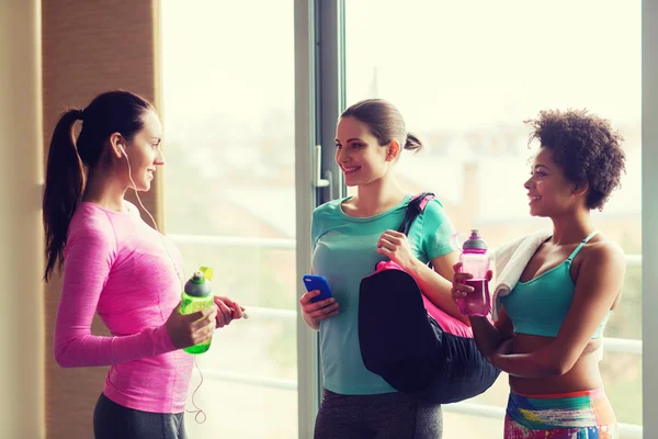 Gelukkig vrouwen met flessen water in de sportschool — Stockfoto