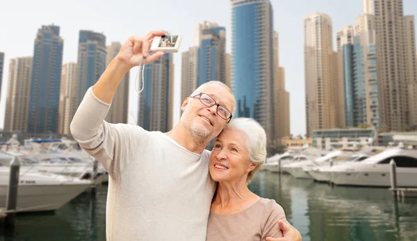 Senior couple taking selfie with camera at harbor — Stock Photo, Image