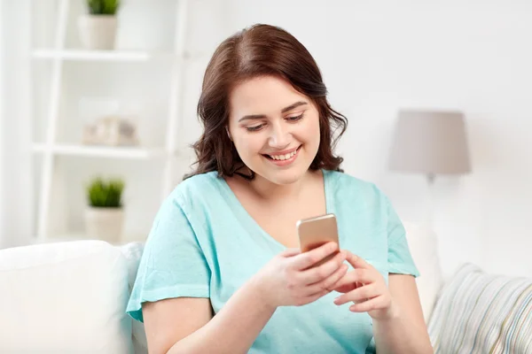 Felice plus size donna con smartphone a casa — Foto Stock