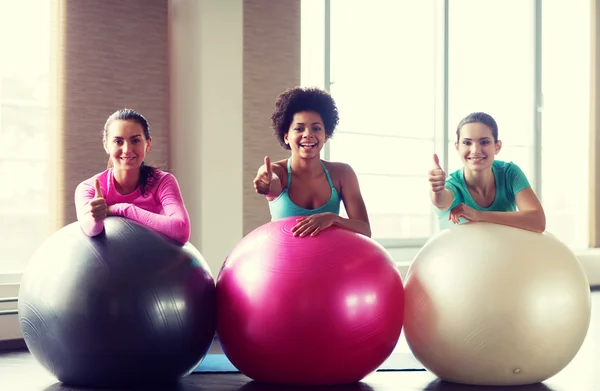 Grupp leende kvinnor med träningsbollar i gym — Stockfoto