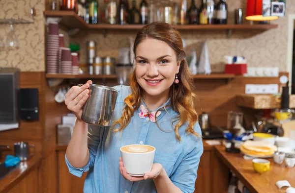 Женщина-бариста наливает сливки в чашку в кафе — стоковое фото