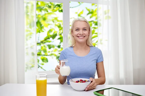 Mujer con leche y copos de maíz desayunando —  Fotos de Stock