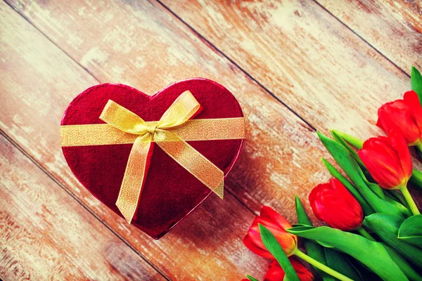 Close up of red tulips and chocolate box — Stock Photo, Image