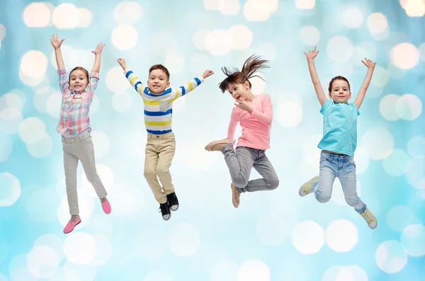 Gelukkige kleine kinderen springen over blauwe lichten — Stockfoto