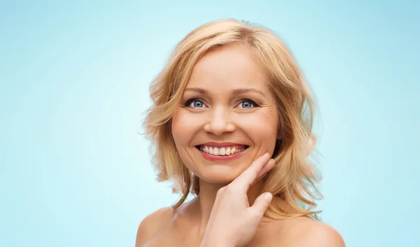 Lachende vrouw met blote schouders raken gezicht — Stockfoto