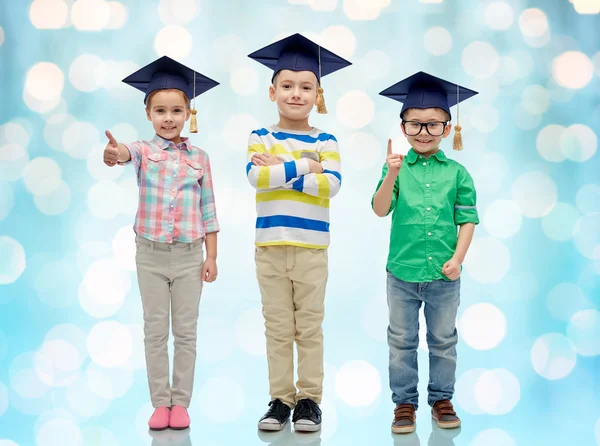 Szczęśliwe dzieci w licencjat kapelusze i okulary — Zdjęcie stockowe