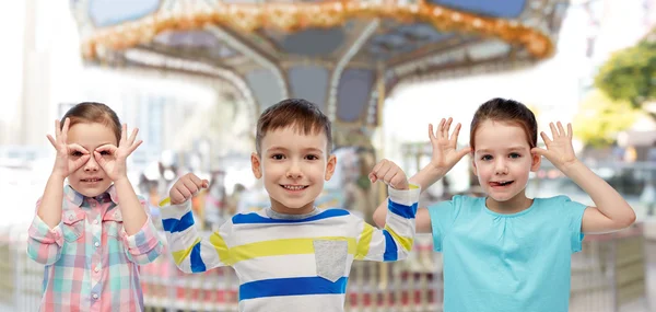 Happy little children having fun over carousel — Stock Photo, Image