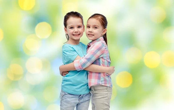 Щасливі усміхнені маленькі дівчата обіймаються — стокове фото