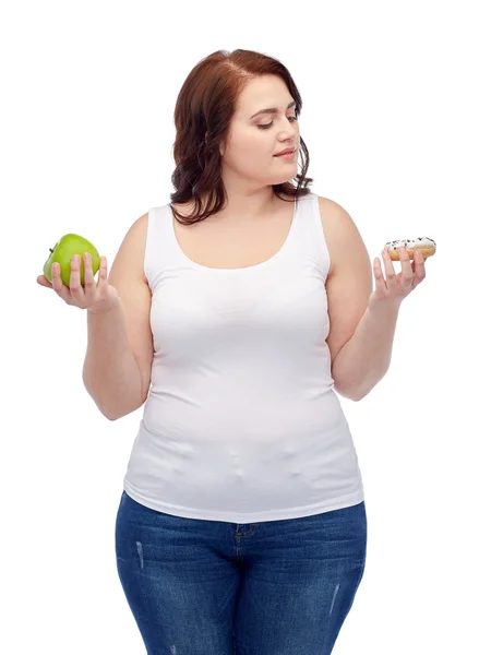 Mujer joven más tamaño elegir manzana o galleta —  Fotos de Stock