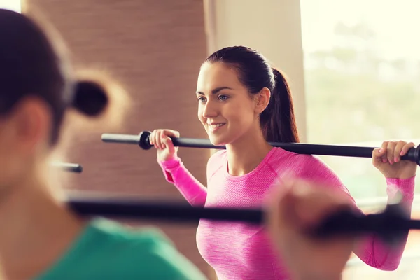 Grupp människor tränar med barer i gym — Stockfoto