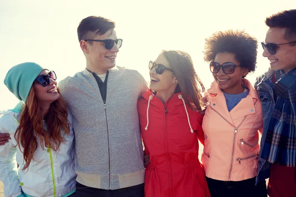 Happy teenage friends in shades talking on street — Stock Photo, Image