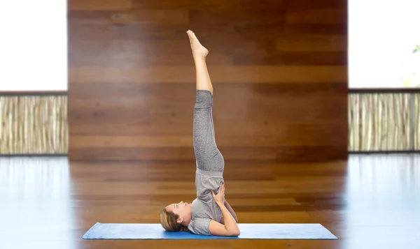Žena dělat jógu v shoulderstand pozice na mat — Stock fotografie
