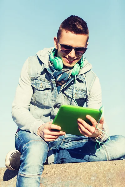 Heureux jeune homme avec tablette PC et écouteurs — Photo