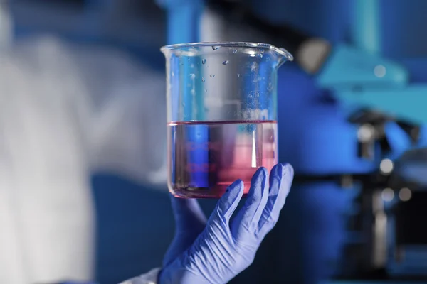 Close-up van de hand met glas in chemische lab — Stockfoto