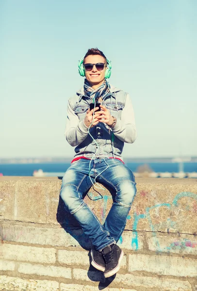 Heureux jeune homme avec tablette PC et écouteurs — Photo