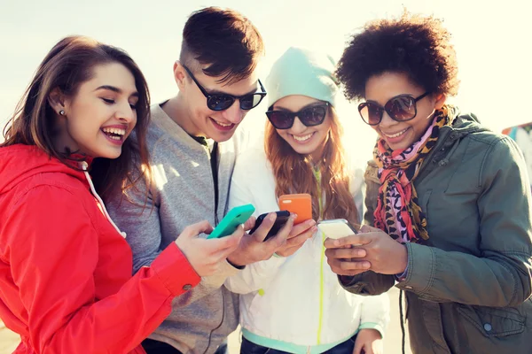 Amici sorridenti con gli smartphone — Foto Stock