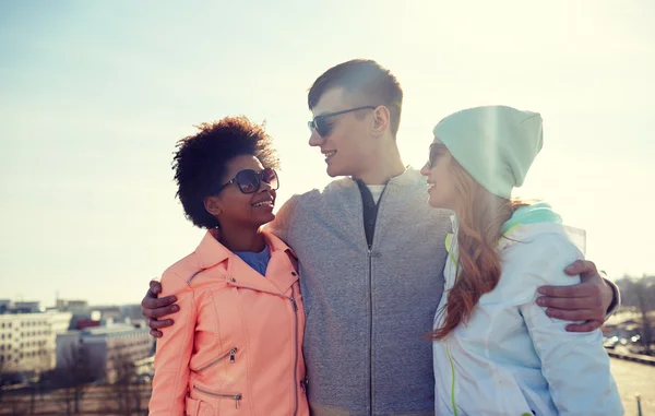 Happy teenage friends in shades talking on street — Stock Photo, Image