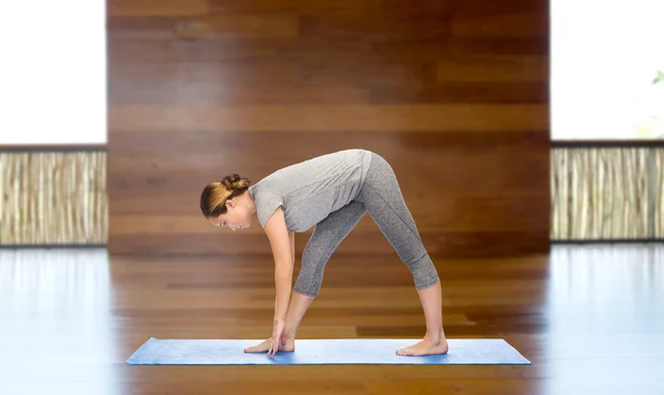 Woman making yoga intense stretch pose on mat — Stock Photo, Image