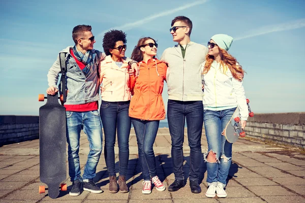 Heureux adolescents amis avec longboards sur la rue — Photo