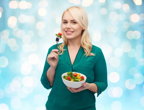 Sorrindo jovem mulher comendo salada de legumes — Fotografia de Stock