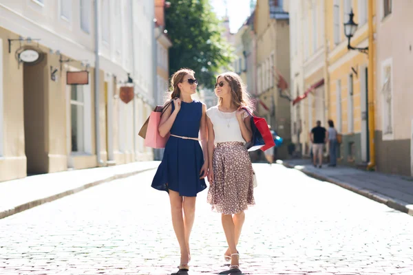 Mulheres felizes com sacos de compras andando na cidade — Fotografia de Stock