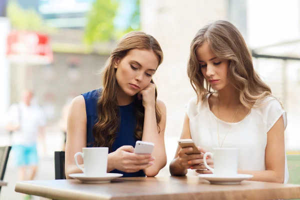 Mujeres con teléfonos inteligentes y café en la cafetería al aire libre —  Fotos de Stock